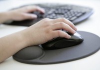 GERMANY, BONN, Health at work, Our picture shows a hand with computer mouse on an ergonomic mousepad with built-in wrist rest made of silicone gel before a computer keyboard.