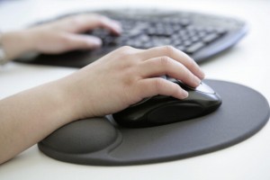 GERMANY, BONN, Health at work, Our picture shows a hand with computer mouse on an ergonomic mousepad with built-in wrist rest made of silicone gel before a computer keyboard.