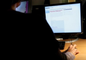 A woman reads a page on the website of t